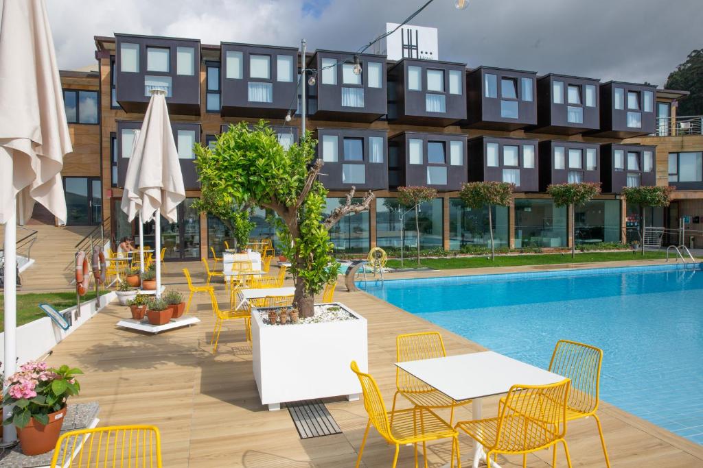 塞代拉赫贝拉酒店的游泳池旁的酒店设有桌椅