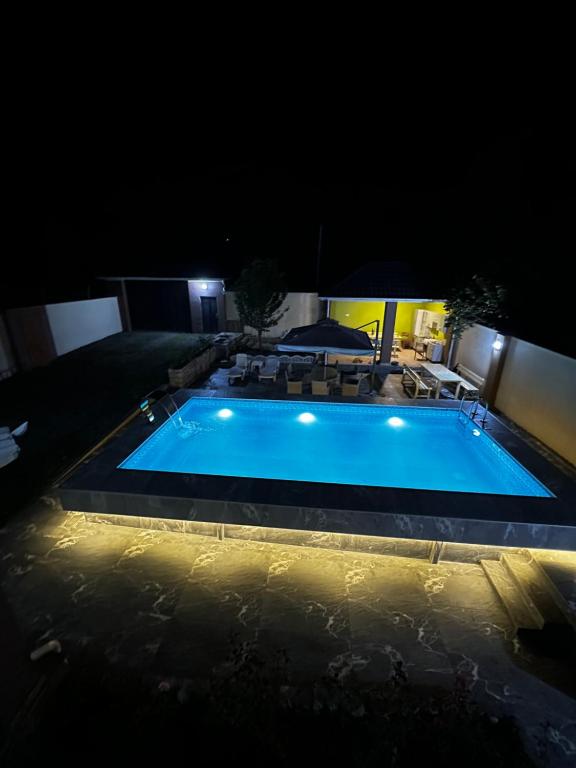 伊斯梅尔雷Xanagah Villa的夜间大型游泳池,灯光照亮