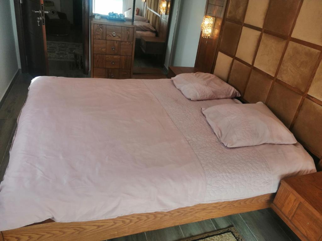 GabèsChez Zina的卧室内的一张带白色床单和枕头的床