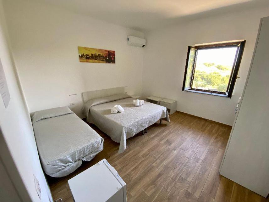 圣尼科拉阿尔切拉La Conchiglia的小房间设有两张床和窗户