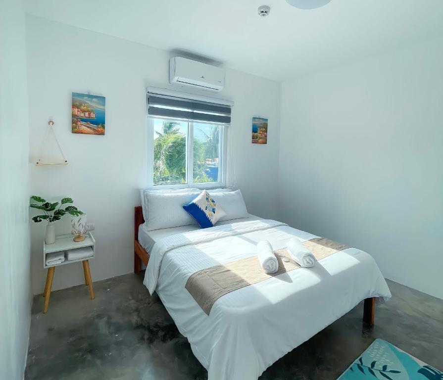 莫阿尔博阿Sunset Paradise Moalboal的卧室设有一张白色大床和一扇窗户。