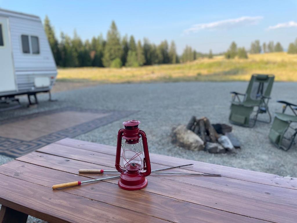 海登Quiet Country Rimrock Retreat的坐在湖边野餐桌上的红灯笼