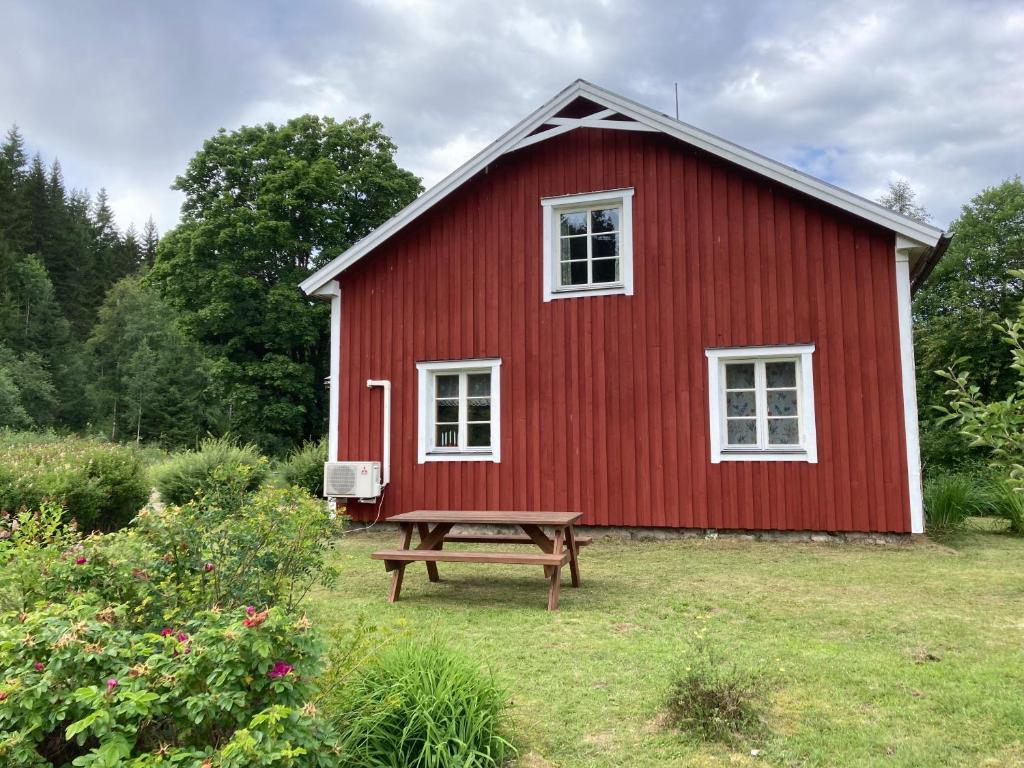 希塞里贝克Branäs Holiday Home的前面的红色谷仓,设有野餐桌