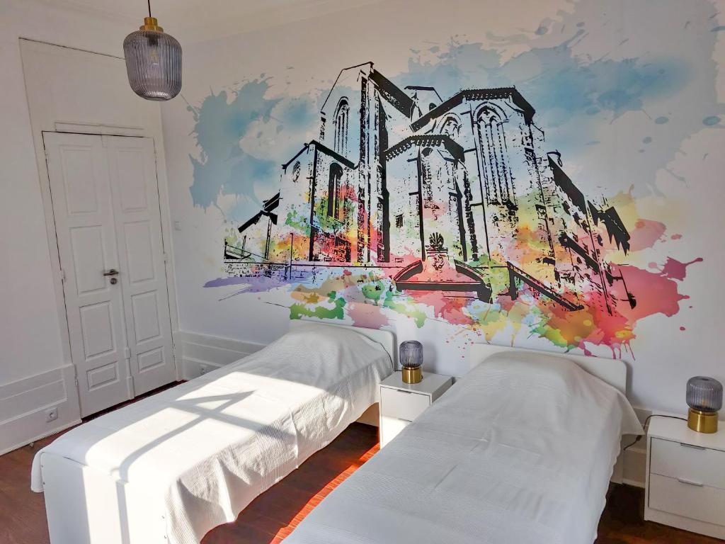 波尔图OLOPO的一间卧室设有两张床,墙上挂着一幅画