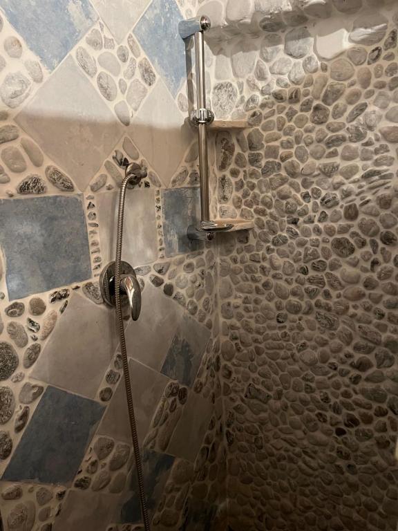 伊索拉迪卡波里祖托B&B del Ponente的墙上有岩石的浴室里设有淋浴