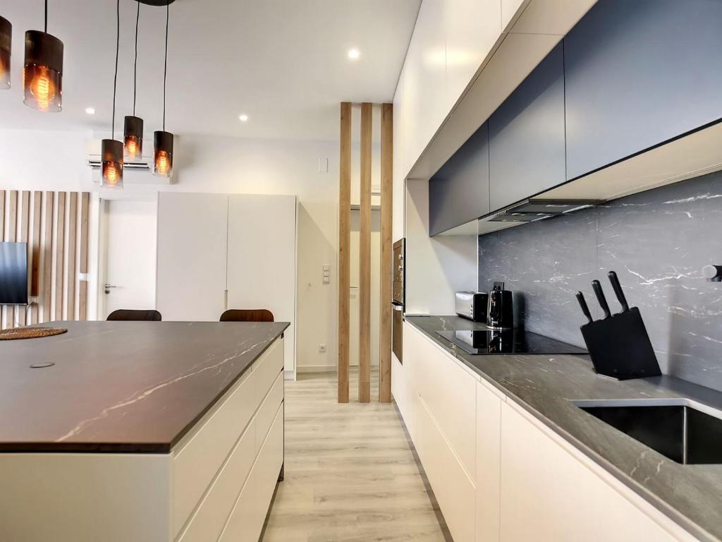 欧瓦O Flamingo Apartments的厨房配有白色橱柜和黑色台面