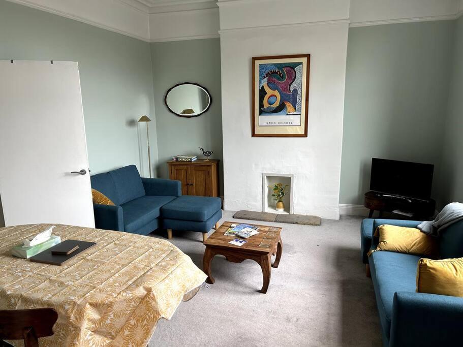 哈罗盖特Suze's Stays的客厅配有蓝色的沙发和咖啡桌