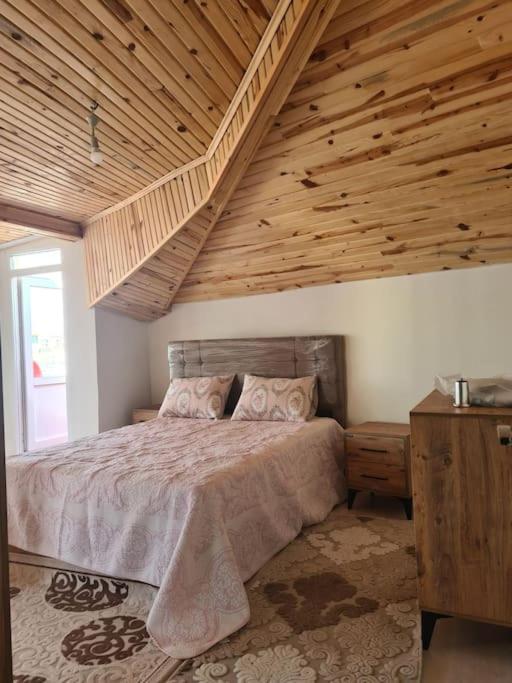 伊斯坦布尔İstanbulun merkezinde lüx 2 odalı daire的一间卧室设有一张带木制天花板的大床