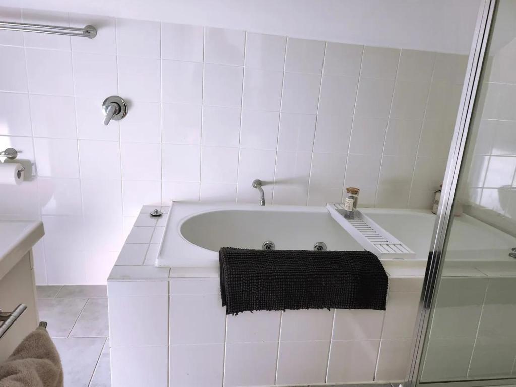 墨尔本Dreamhouse的白色的浴室设有浴缸和淋浴。