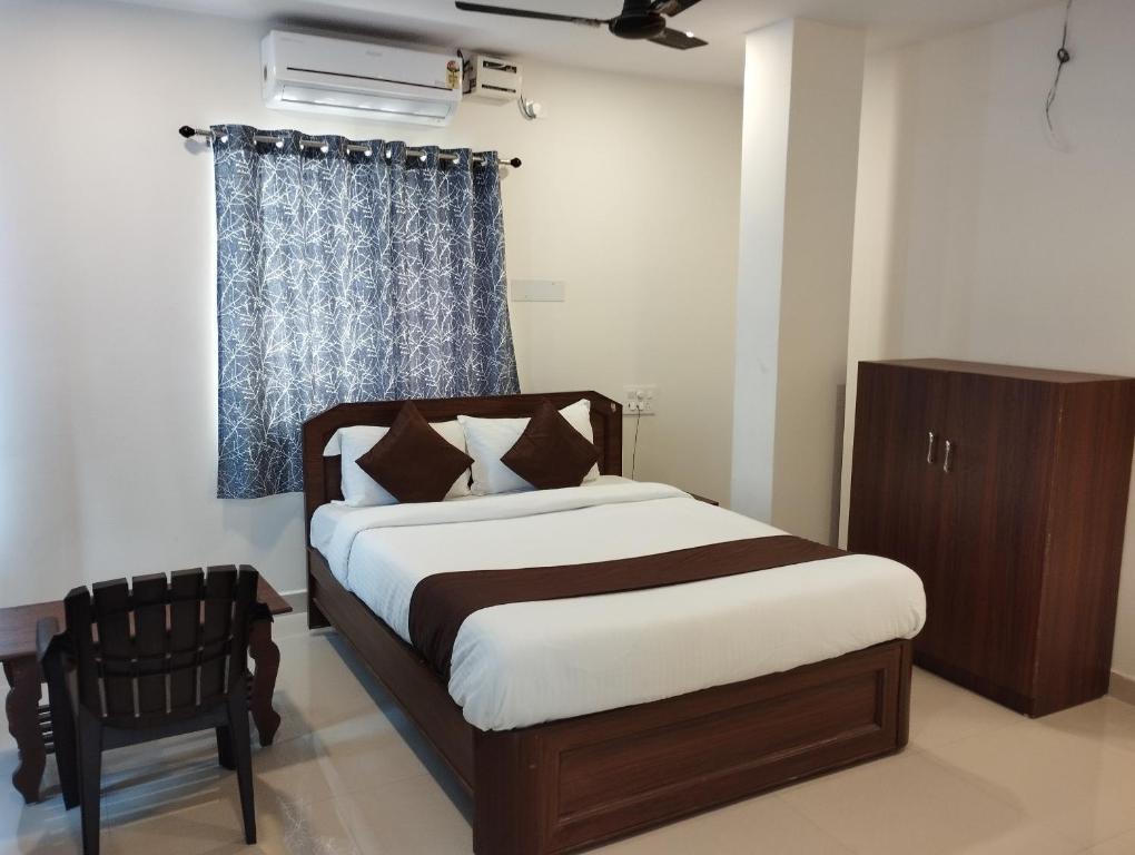 海得拉巴HOTEL VIRAT GRAND的卧室配有床、椅子和窗户。