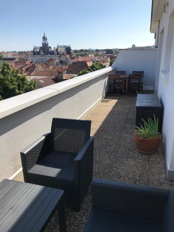 维希Appartement avec vue panoramique的屋顶上带桌椅的阳台