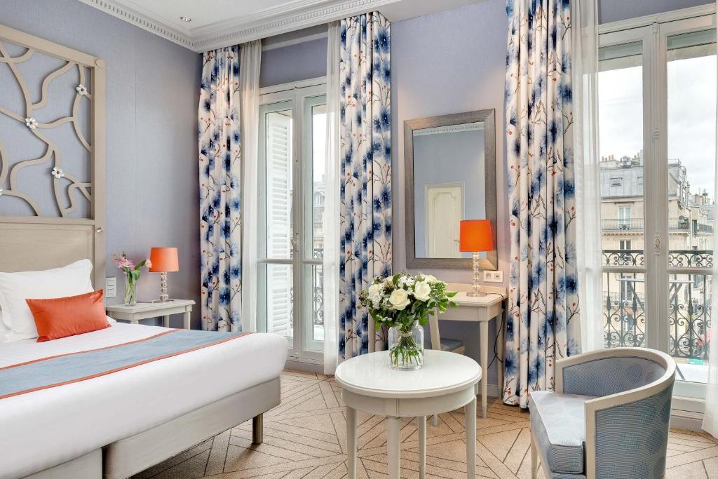 巴黎伊特莱尔辉煌饭店的卧室配有1张床、1张桌子和1把椅子
