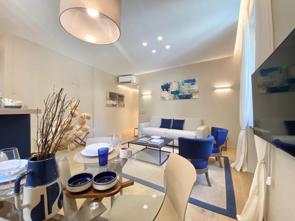 波托菲诺San Giorgio Uno 60mq 1b/1b的客厅配有玻璃桌和蓝色椅子