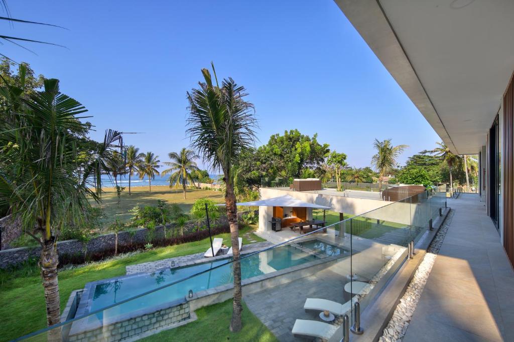 塞隆贝拉纳克Villa Serangan - Private Beach Access的享有带游泳池和棕榈树的别墅的外部景色
