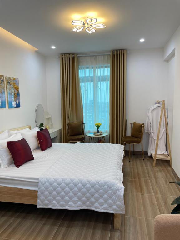 河内Nhà Nghỉ Huyền Anh的卧室配有带红色枕头的大型白色床