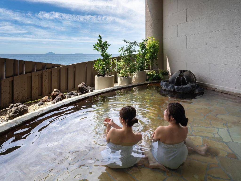 东伊豆町Atagawa Ocean Resort的两个女人坐在游泳池里
