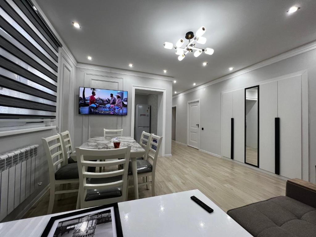 努库斯Entire Apartment in Central Nukus的一间设有桌子和墙上电视的用餐室