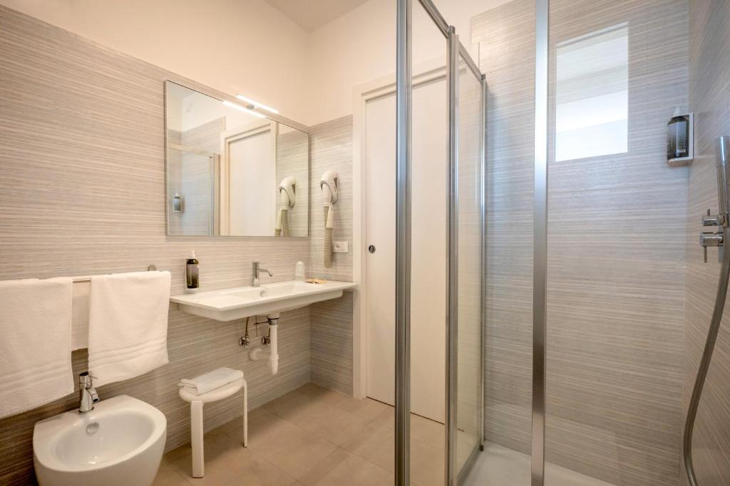 卡奥莱Hotel Parigi的浴室配有卫生间、盥洗盆和淋浴。