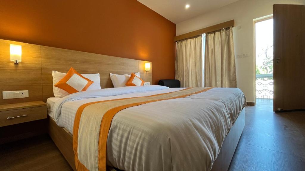 克久拉霍Hotel The Bundela - Khajuraho, Madhya Pradesh的酒店客房,设有一张带橙色墙壁的大床