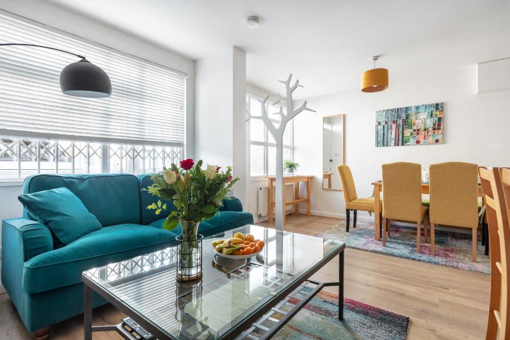 伦敦- Cozy 3 Bed House on a Quiet Mews -的客厅配有蓝色的沙发和桌子