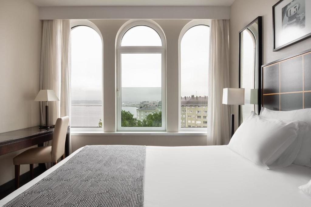 拉科鲁尼亚欧洲之星拉科鲁尼亚城市酒店的卧室配有一张床、一张书桌和窗户。