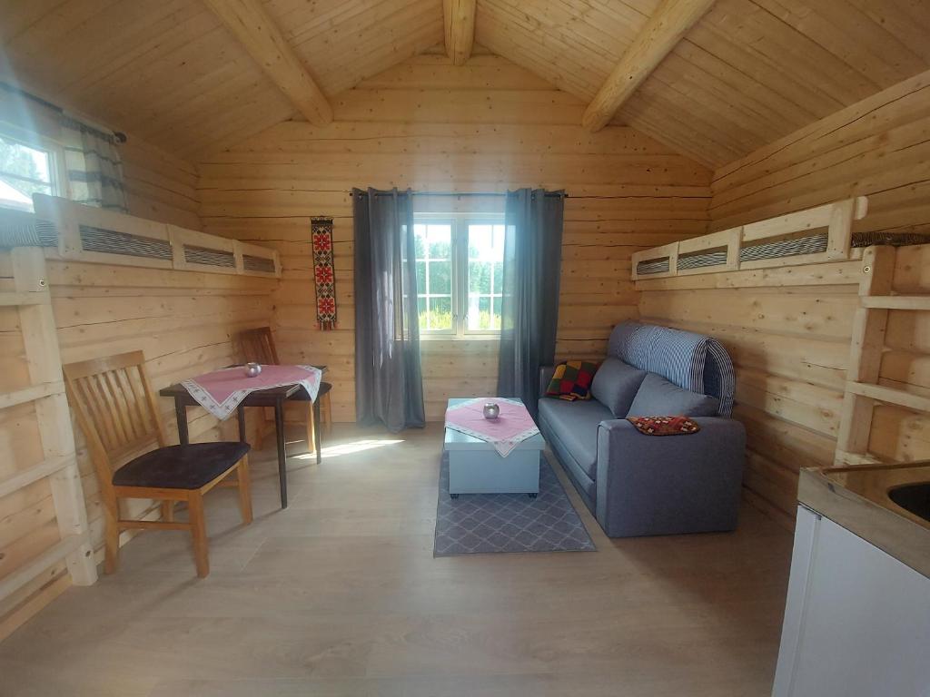 Hattfjelldalsmall camping cabbin with bathroom near by的小木屋的客厅配有沙发和桌子