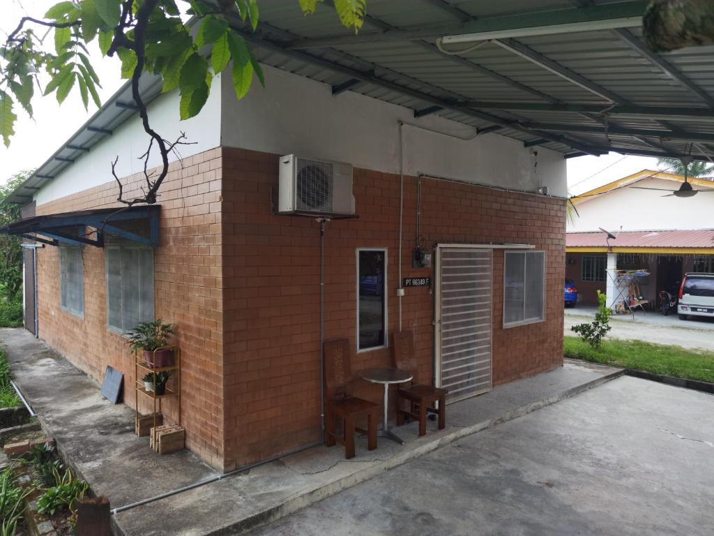巴生Akmal Homestay Klang的一座小砖砌建筑,配有桌子和桌子