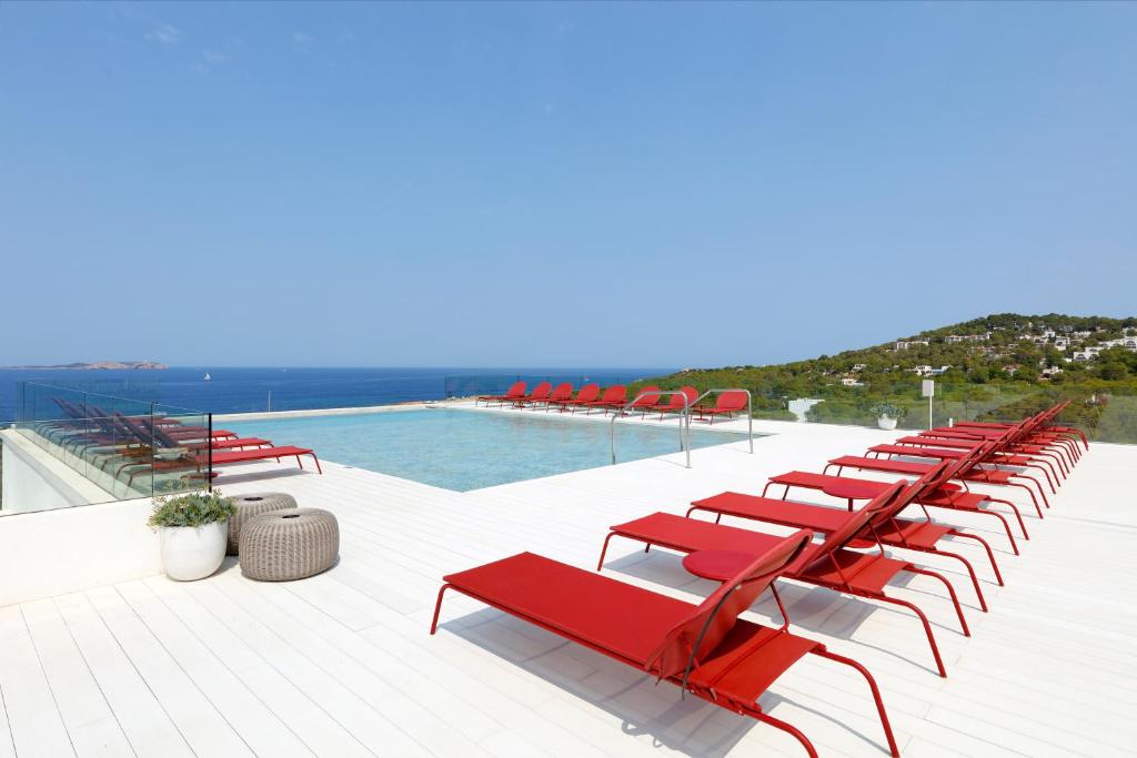 圣安东尼奥TRS Ibiza Hotel -All Inclusive Adults Only的游泳池旁一排红色椅子