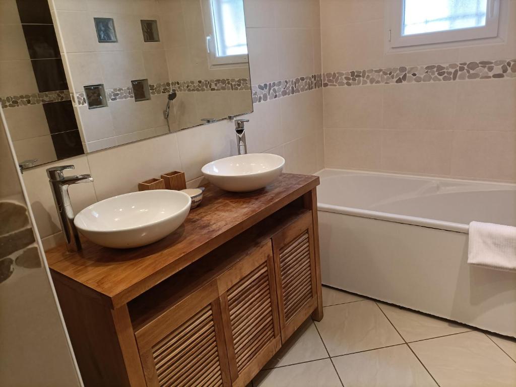 Sainte-EulalieLa maison dans les noyer的浴室配有两个盥洗盆和浴缸。