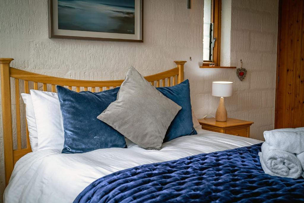 InshKirkstone Lodge的一间卧室配有一张带蓝色和白色枕头的床