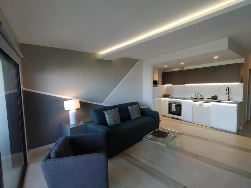 圣米格尔德阿沃纳Las Meninas Tenerife的一间带蓝色沙发的客厅和一间厨房