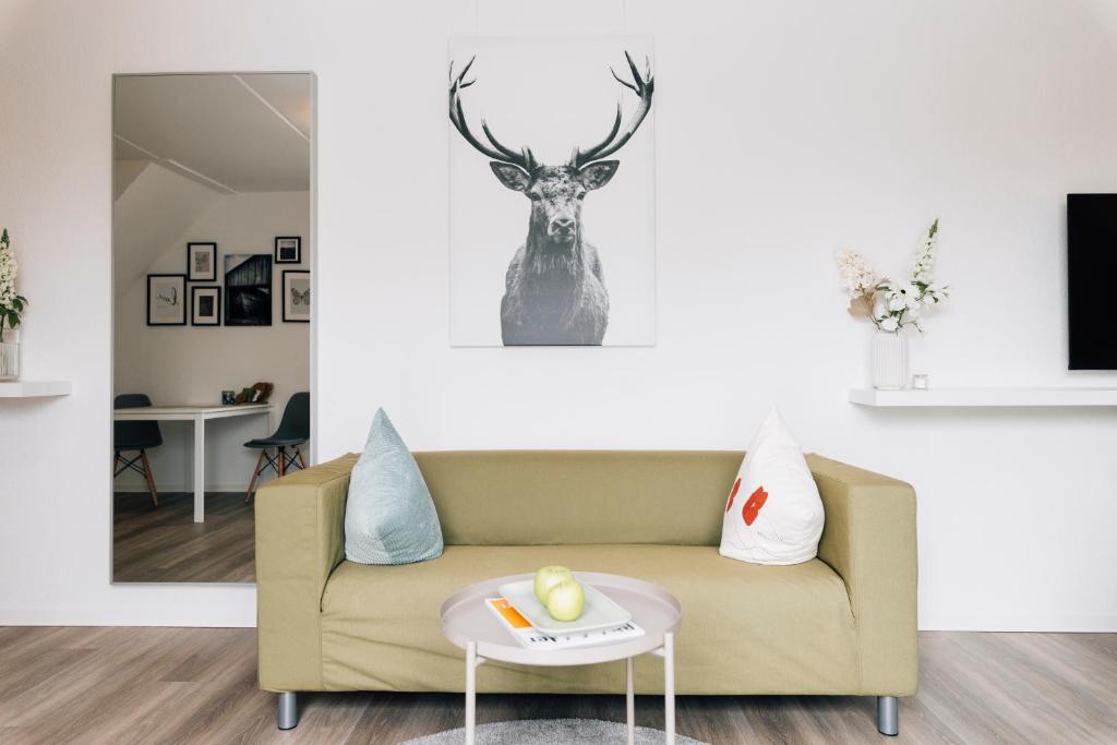 比勒费尔德New Living City Appartement的客厅配有沙发和墙上的鹿