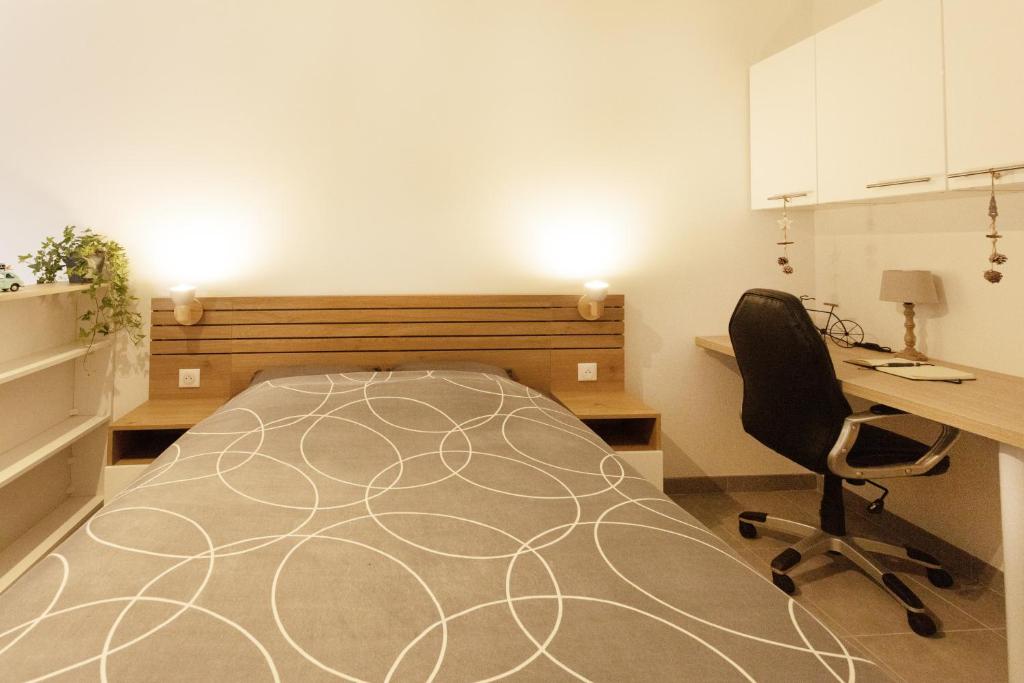 Saint-Paul-de-VaraxLogement équipé的一间卧室配有一张床、一张桌子和一把椅子