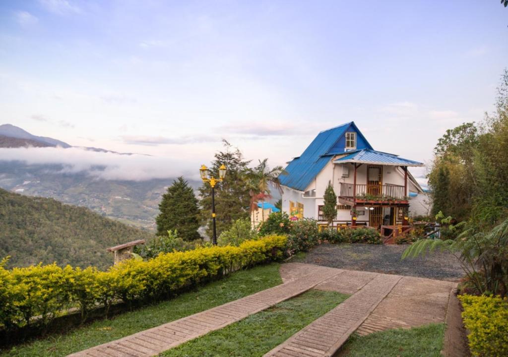 卡利Finca Villarreal的山顶上带蓝色屋顶的房子