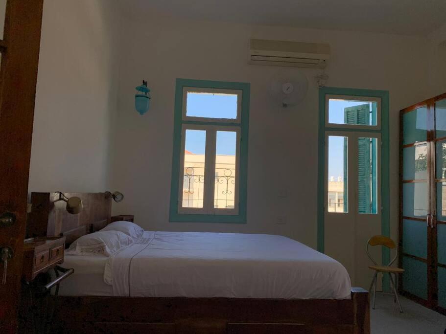 特拉维夫Central, Authentic and Stylish Old Yafo Experience的卧室配有白色的床和2扇窗户。
