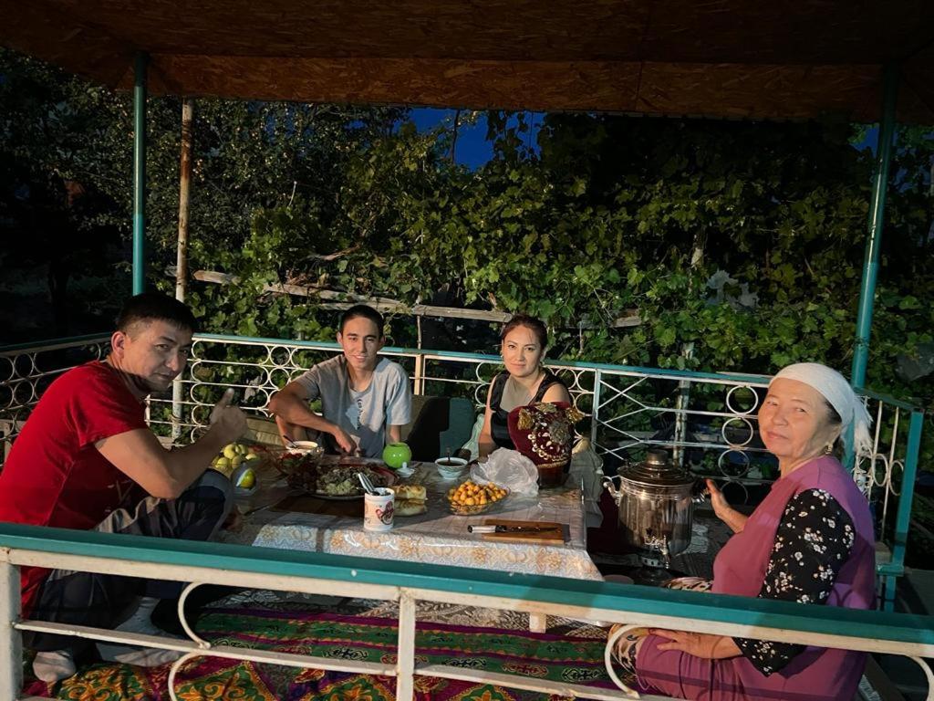 TürkistanGuest house В гостях у Лаззат的一群人坐在桌子旁