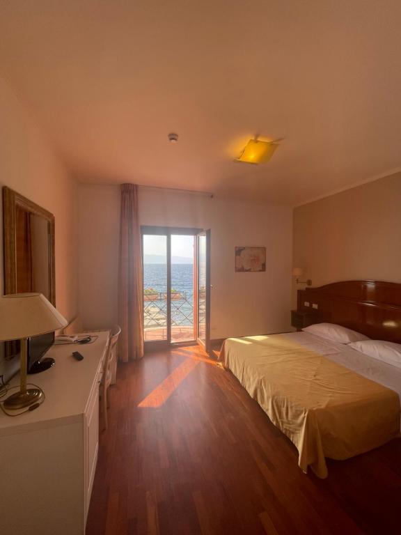 雷焦卡拉布里亚Hotel La Lampara的酒店客房,设有床和滑动玻璃门