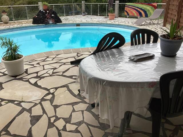 圣贝努瓦Appartement dans propriété reposante的游泳池前的桌椅