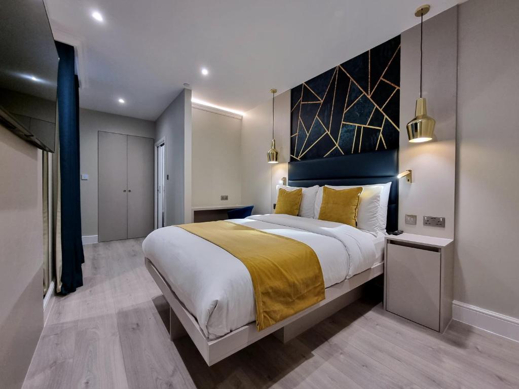 伦敦NOX Kensington Gardens的一间卧室配有一张带黄色毯子的大床