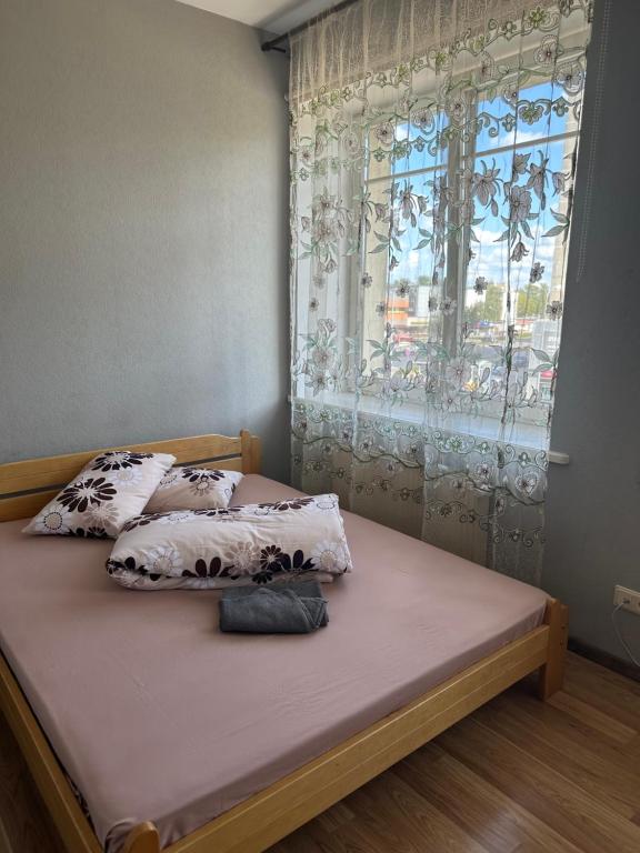 陶格夫匹尔斯帕拉迪泽的卧室内的一张带两个枕头的床和一个窗户