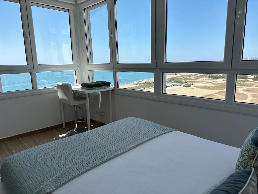 马拉加Sunstay - Seaview Guadalmar的一间卧室配有一张床和一张带窗户的书桌。