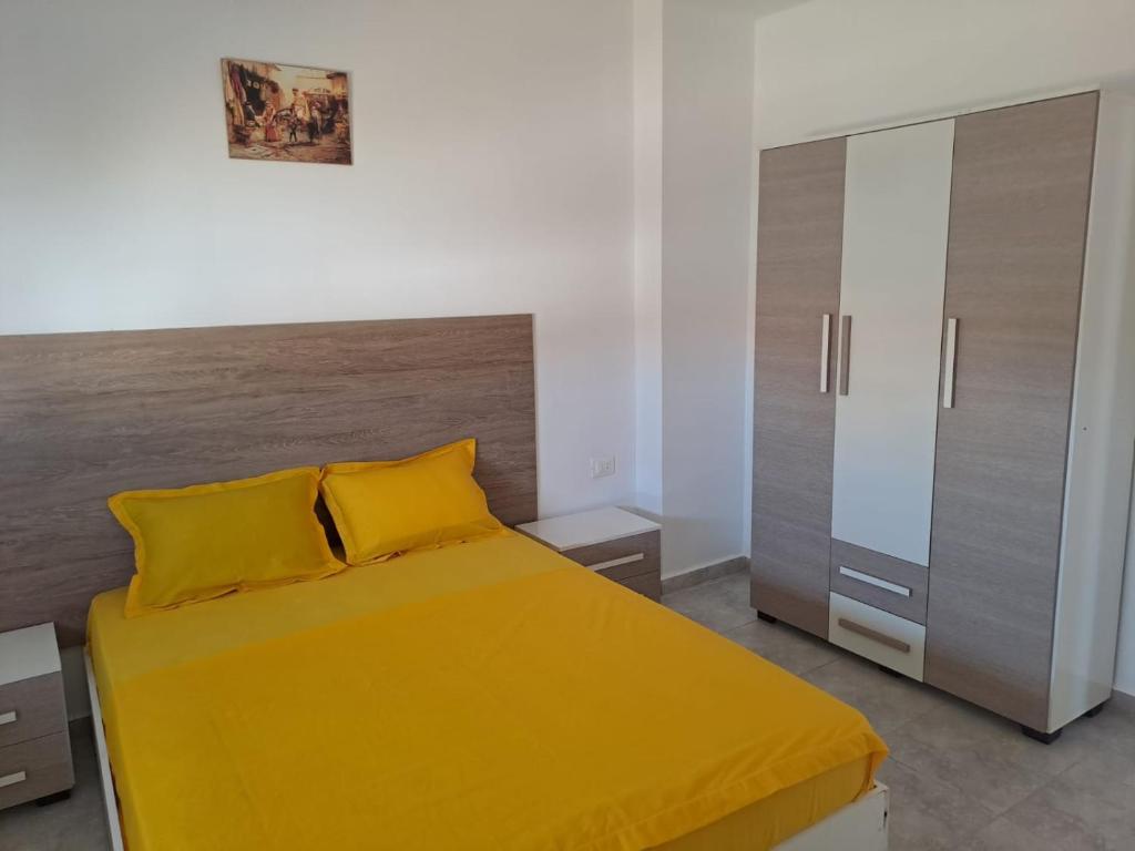 KerkoueneDar El Yasmine 2的一间卧室配有黄色的床和橱柜