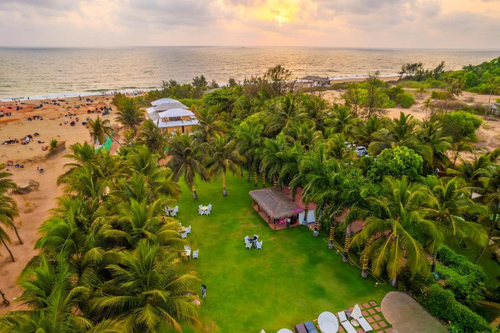 坎多林O Hotel Goa, Candolim Beach的海滩上的度假村的空中景致