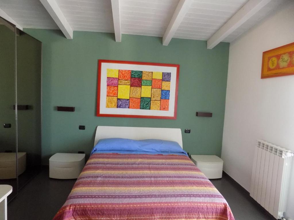 巴里Attico Stazione - Montello 16的卧室配有一张床,墙上挂有绘画作品
