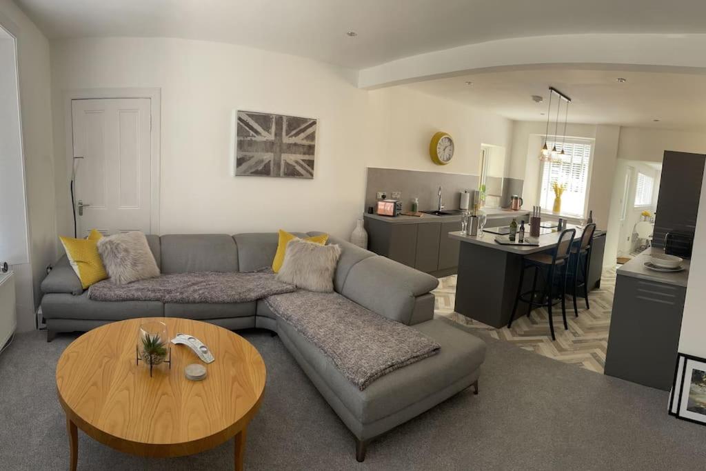 波尔蒙特Fantastic home in Brightons, Falkirk.的带沙发和桌子的客厅以及厨房。