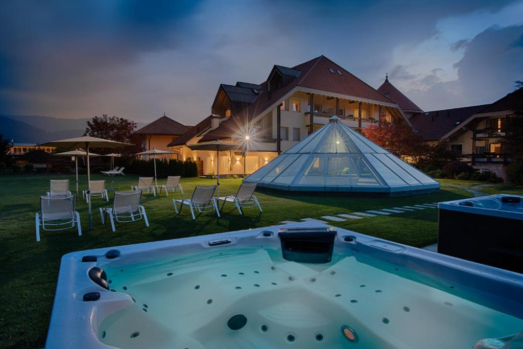 布鲁尼科Schönblick - Sport & Active Hotel的房屋的院子内的热水浴池