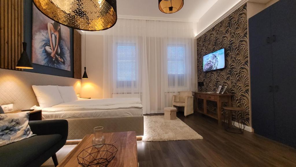 久洛Glamour Apartman的一间卧室设有一张床和一间客厅。