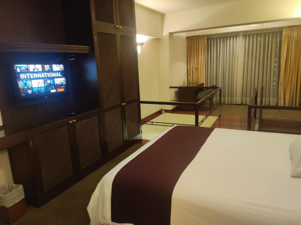 利马Miraflores Confort Suite的配有一张床和一台平面电视的酒店客房