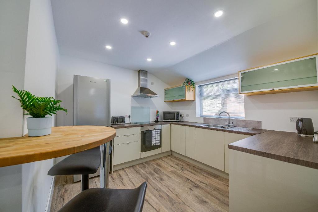 谢菲尔德6bd Home-Contractors A+ Location的厨房配有木桌和台面