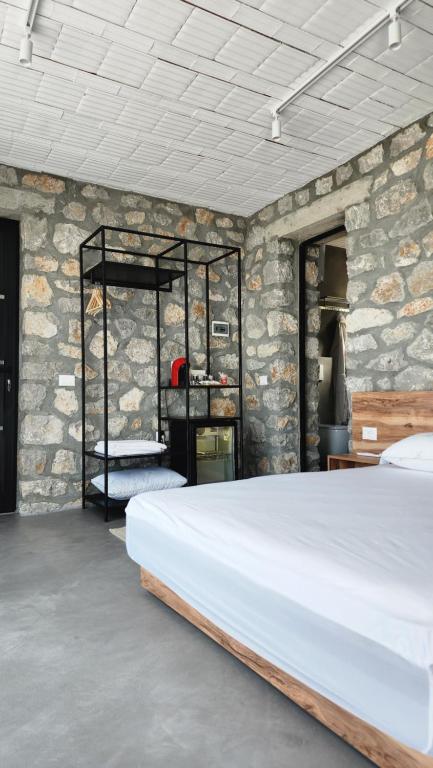 ŠirokaRUSTICO的一间卧室设有一张床和石墙